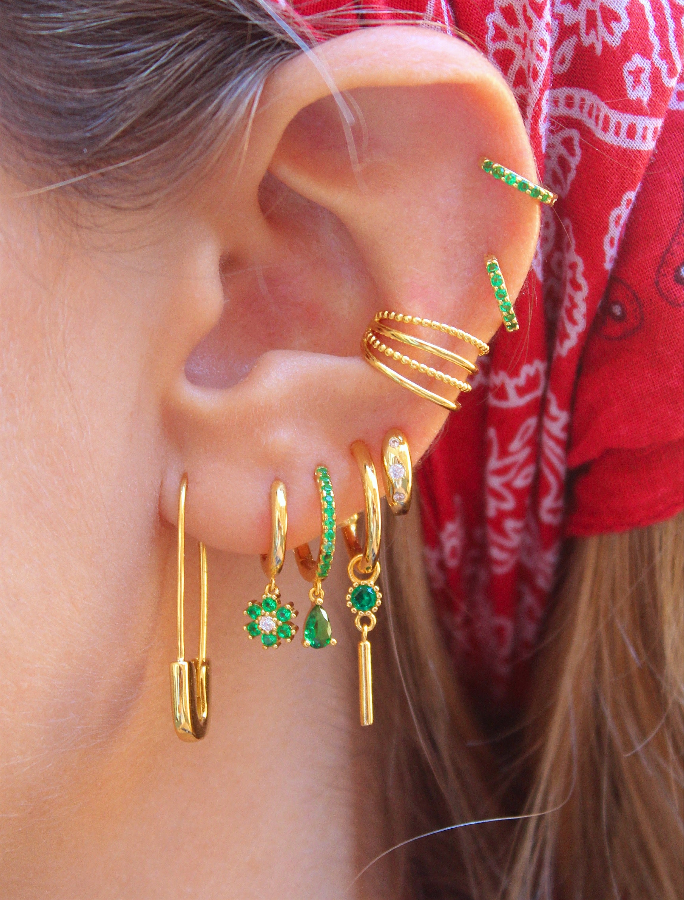 Aro Huggie dorado con flor de margarita y circonita verde